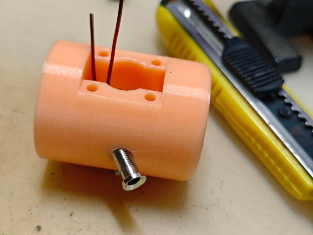 the antenna base, the banana jack with enamel wire inserted into the hole on the 3d printed antenna base