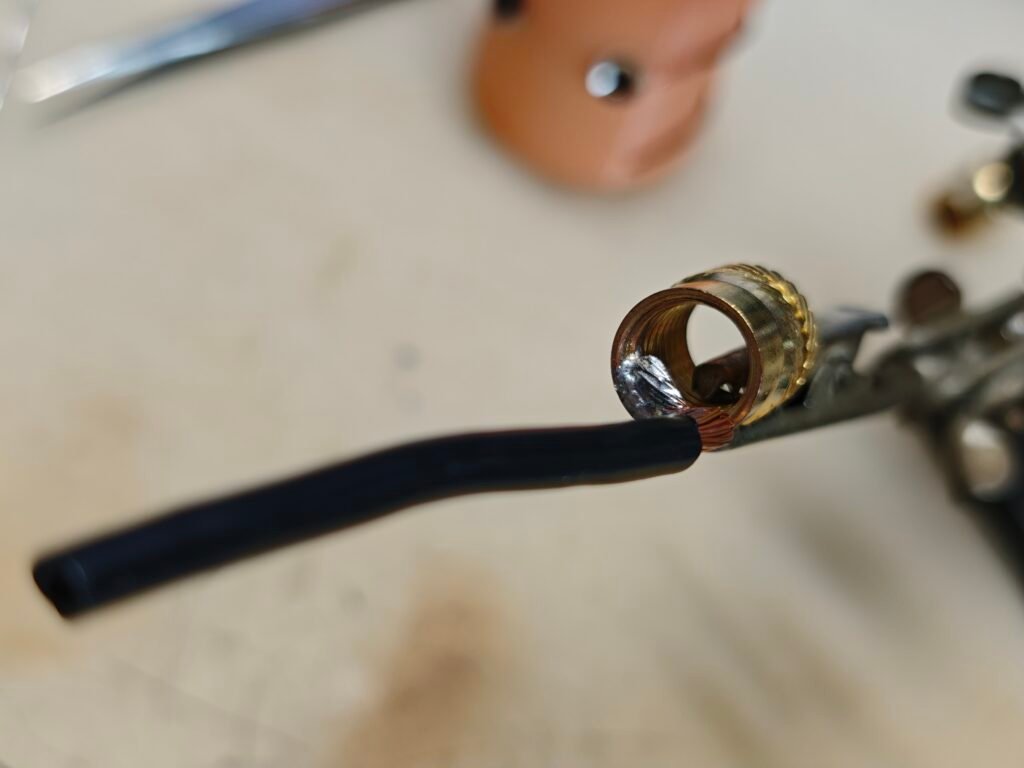 the antenna base, wire soldered onto the M10 nut as the connection from the whip to the central conductor of a so239 connector