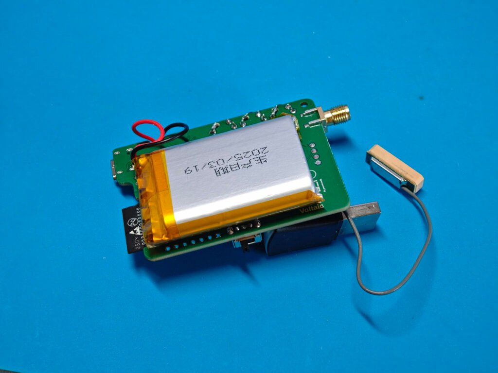 Fully assembled custom Icarus‑v2 Meshtastic node board with battery at back