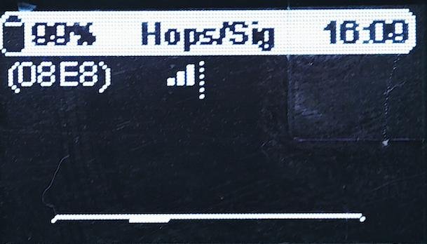 Meshtastic node OLED screen displaying hops count and signal strength indicator