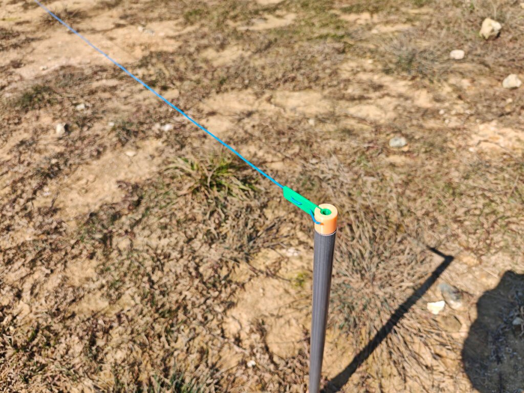 Radial wire end hooked to PVC pipe cap ground stake