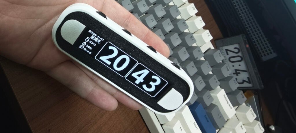 JingShi (Still Stone) Desktop Clock finished prototype in hand, showing 3.12-inch OLED display with time, date, temperature/humidity data, and six buttons.