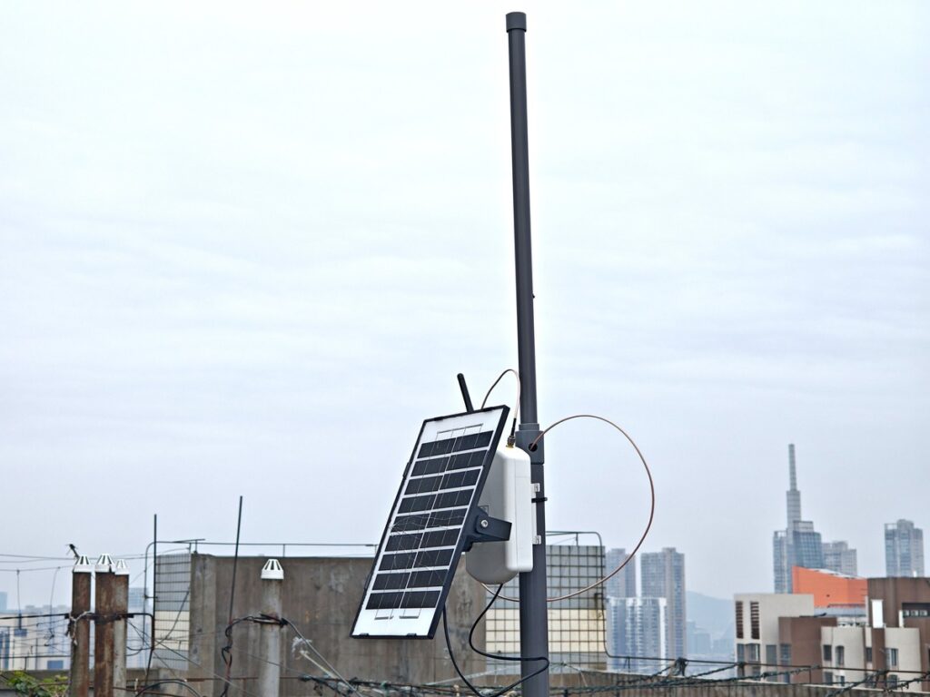 Rooftop Meshtastic base station with homemade PVC J-Pole antenna and city skyline