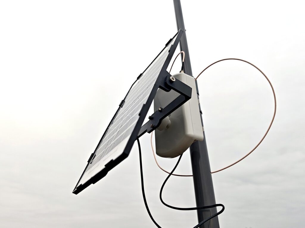Solar-powered Meshtastic node with copper cable loop and rooftop J-Pole antenna setup