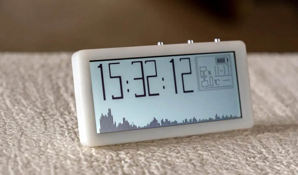 Music visualizer clock showing time display and spectrum animation on reflective LCD