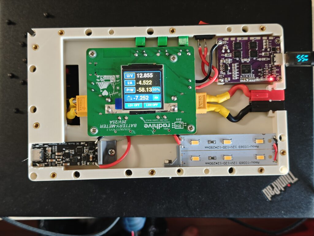 Open field battery enclosure showing the battery meter board installed between a 4S LiFePO4 pack and the output wiring.
