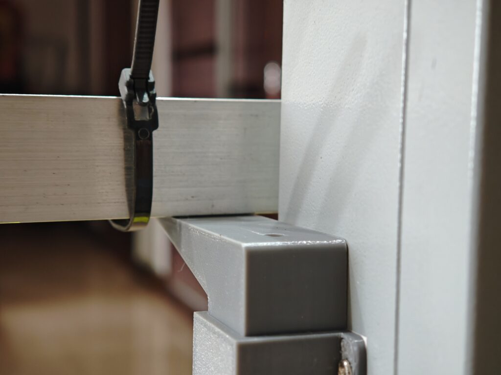 A close-up shot of both the angle bar and the 3D printed antenna support, showing the 3D printed part stops the angle bar from moving downward so as to protect the gears in EL motor.