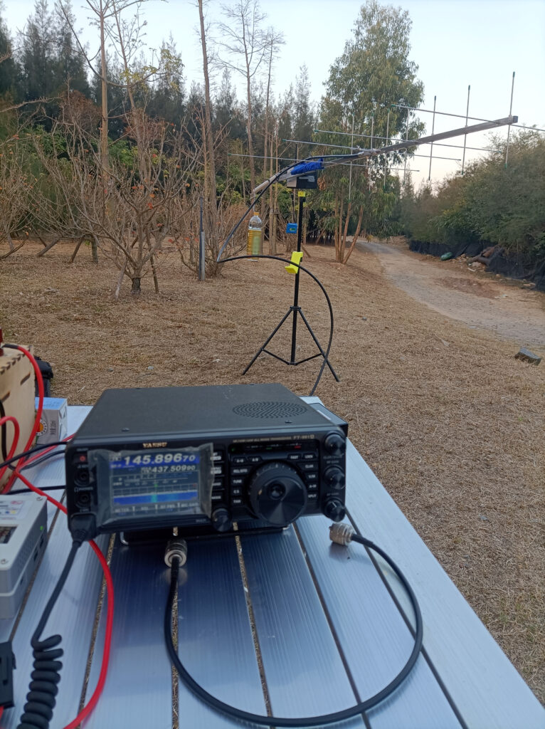 Real outdoor field operation: The DIY antenna rotator with a Yagi antenna mounted is pointing the antenna to a satellite instructed by a control software installed on the phone, actively talking to the International Space Station (ISS) via Yaesu FT-991A transceiver on a table.